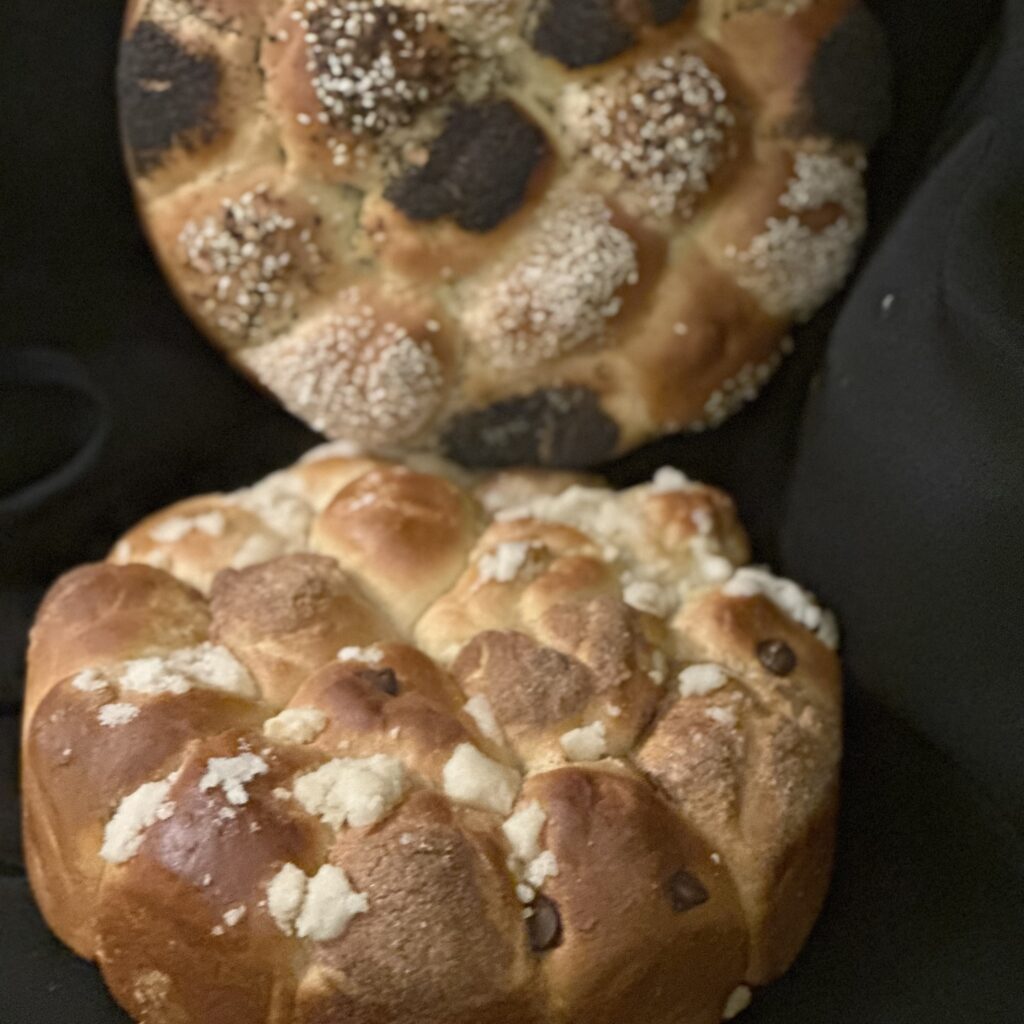 Close-up of salted pretzel buns with coarse white salt crystals on a dark background.