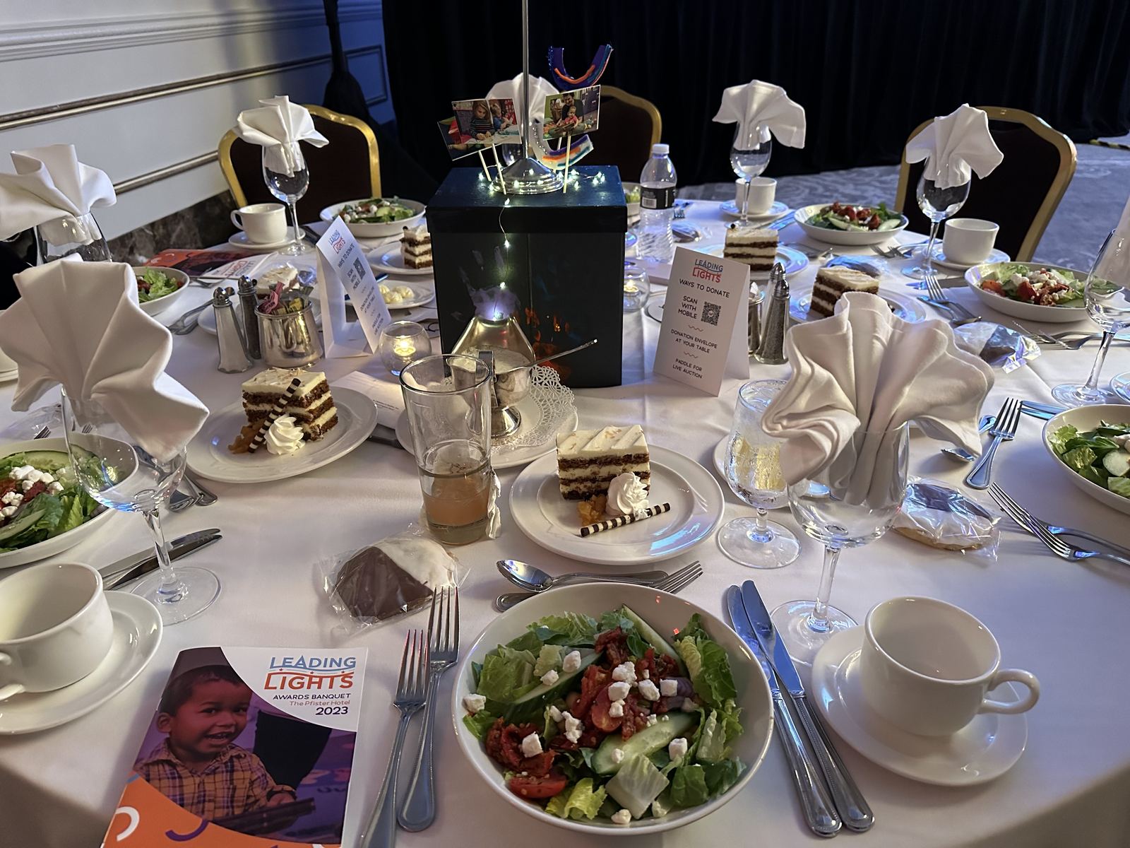 Formal event table set with a fresh salad and place settings